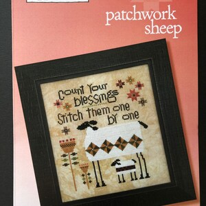 May include: A cross-stitch pattern featuring a white sheep with black markings and a smaller white lamb with black markings. The sheep are surrounded by flowers and the text "Count Your Blessings Stitch Them One By One". The pattern is framed in black and the background is pink.