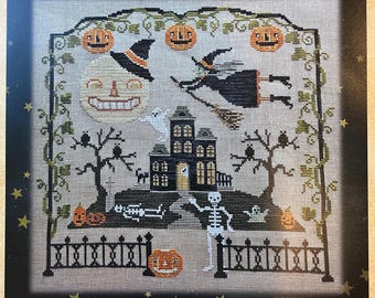 May include: A cross-stitch pattern on light gray fabric featuring a Halloween scene with a haunted house, a skeleton, a witch on a broomstick, a smiling moon, ghosts, owls, and pumpkins, all framed by a black iron fence and vine-covered arch.