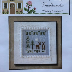 May include: Cross stitch pattern featuring a snowy forest scene with two reindeer, trees, and a star. The pattern is titled "Frosty Forest" and is from Country Cottage Needleworts, "Snowy Reindeer".