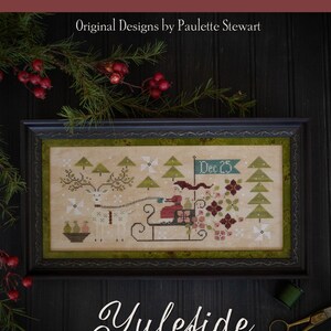 Peut inclure: Un sampler de point de croix encadré représentant une scène d'hiver avec un cerf tirant un traîneau transportant une figurine en rouge. Le sampler est intitulé "Yuleside Delivery" et a une bordure verte. Le cadre est noir avec un bord décoratif. Le sampler est présenté sur une surface en bois foncé avec une bobine de fil et une paire de ciseaux.