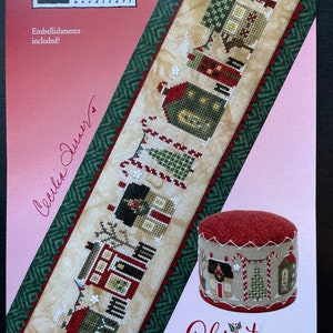 May include: Cross stitch pattern for a Christmas tiny town with a red and white candy cane design. The pattern is from Heart in Hand needleart.