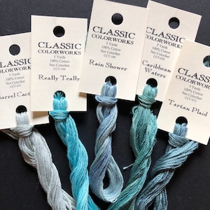 May include: Five spools of Classic Colorworks embroidery floss in shades of blue and green. The floss is labeled with the color name and color code. The colors are: Barrel Cactus, Really Teally, Rain Shower, Caribbean Waters, and Tartan Plaid.