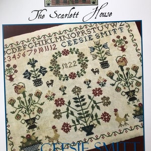 May include: A cross-stitch sampler titled "The Scarlett House" by Ceesie Smitt. The sampler features a brick house with a wreath, flowers, and the date 1822. The sampler is a Dutch sampler.