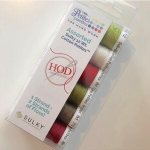 May include: A package of six spools of Sulky Cotton Petites embroidery floss in assorted colors. The package includes the text "Petites palettes" and "Assorted Sulky 12 Wt. Cotton Petites".