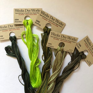 May include: Five spools of Weeks Dye Works floss in shades of green. The floss is hand-dyed and comes in the following colors: Juniper, Bullfrog, Celadon, Caper, and Absinthe.