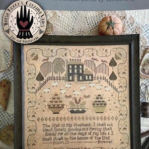 May include: A framed cross-stitch sampler featuring a house, sheep, and floral motifs on a tan background. The text reads: The Lord is my shepherd, I shall not want. Surely goodness & mercy shall follow me all the days of my life & I shall dwell in the house of the Lord forever. Psalm 23, Harriet Baker 1840.