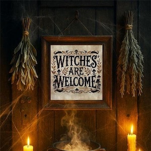 May include: A framed sign with the text "Witches Are Welcome" in a gothic font. The sign is surrounded by dried herbs and lit candles, creating a spooky Halloween theme. The frame is dark brown.