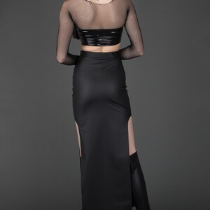 May include: A black long skirt with a side slit and a black mesh top. The skirt is made of a shiny material and has a high waist.