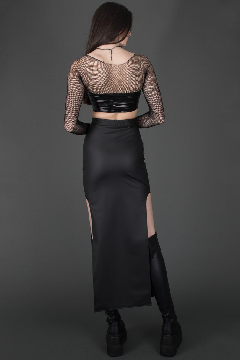 May include: A black long skirt with a side slit and a black mesh top. The skirt is made of a shiny material and has a high waist.