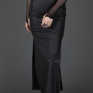 May include: A black maxi skirt with a side slit and a zipper detail. The skirt is made of a stretchy, smooth fabric.