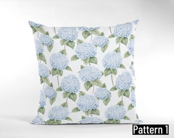 May include: Square pillow with a repeating pattern of light blue hydrangea flowers and green leaves on a white background. The pillow is labeled "Pattern 1" in black text.