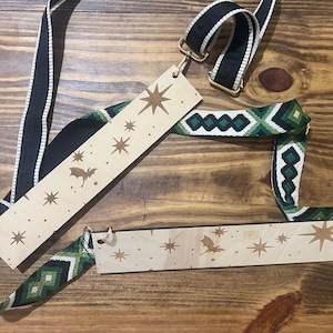 May include: Black and white striped crossbody bag strap with gold-colored hardware. Includes two wooden tags with star and bat cutouts. The strap also features a green and white geometric pattern.