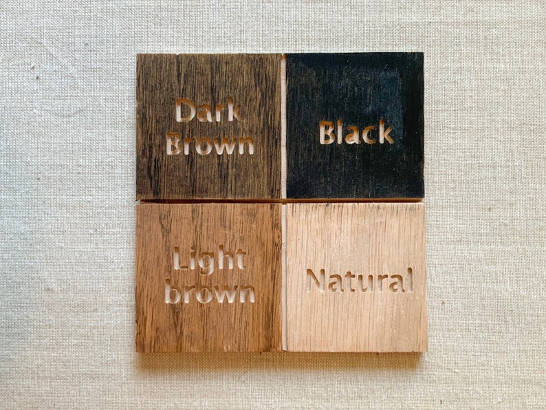 May include: Four wood samples showing different wood stains: dark brown, black, light brown, and natural.