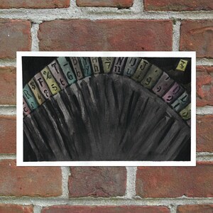 May include: A watercolor painting of a black fan with a colorful alphabet around the edge. The letters are in a rainbow of colors, including pink, yellow, green, blue, and purple.