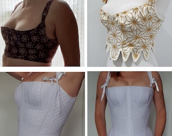 May include: Four different styles of corsets, two with white fabric and two with patterned fabric. The corsets are all in different stages of completion, with some having straps and others not.