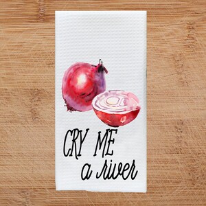 K&ouml;nnte beinhalten: Ein wei&szlig;es Geschirrtuch mit einer Aquarell-Illustration einer roten Zwiebel und dem Text "CRY ME A RIVER".