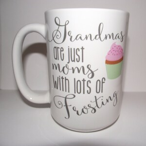 May include: White ceramic mug with a large handle. The mug features the text "Grandmas are just moms with lots of Frosting" in grey script. A cupcake graphic with pink icing and sprinkles is also on the mug.