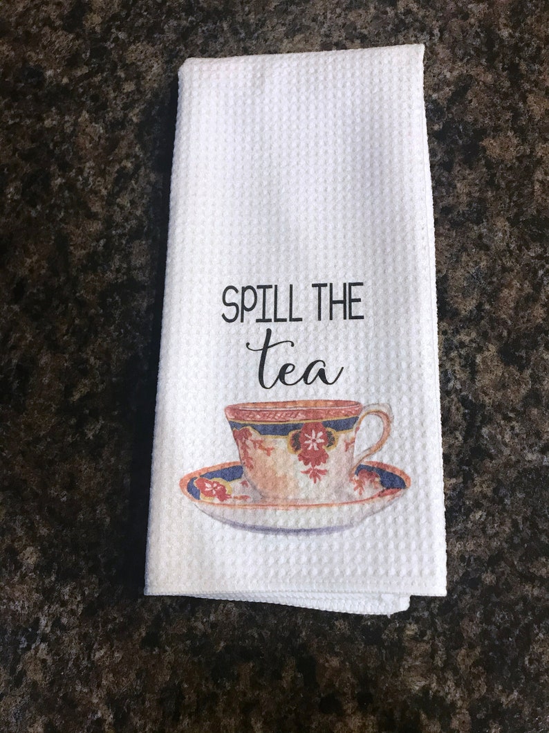 May include: White kitchen towel with the text "Spill the tea" and a vintage teacup and saucer illustration.