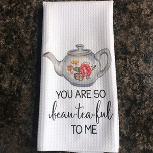 May include: White tea towel with a floral teapot design and the text "You are so beau-tea-ful to me".