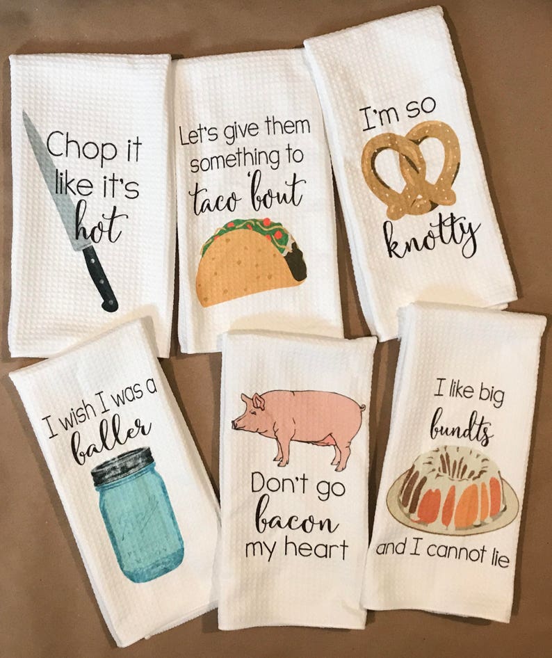 May include: Set of six white kitchen towels with funny food-themed sayings and illustrations. The towels feature sayings like "Chop it like it's hot", "Let's give them something to taco 'bout", "I'm so knotty", "I wish I was a baller", "Don't go bacon my heart", and "I like big bundts and I cannot lie".