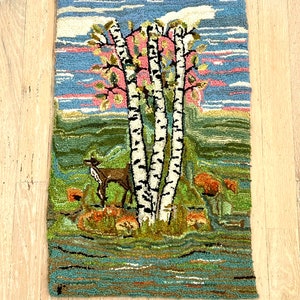 May include: A vintage hooked rug depicting a forest scene with three birch trees, a deer, and a river. The rug has a blue sky with pink clouds, green grass, and orange flowers.