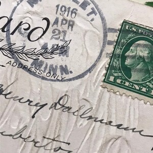 May include: Close-up of a vintage postcard with a U.S. postage stamp. The postcard is stamped with "Nicollet, Minn." and the date "Apr 21, 1916." The stamp features a portrait of George Washington.