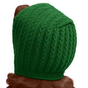May include: A knitted green hat with a textured pattern. The hat is a deep shade of green and appears to be made of a soft yarn. The hat is designed to cover the head and part of the neck.