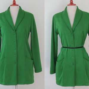 May include: A bright green long-sleeved blazer featuring a shawl collar, five matching green buttons down the front, and two front patch pockets. The garment is displayed on a mannequin, shown both without and with a thin black waist belt.
