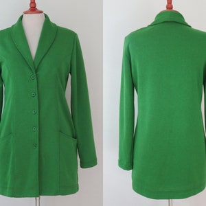 May include: A bright green long-sleeve blazer featuring a shawl collar, five matching green buttons down the front, and two patch pockets. The garment is displayed on a mannequin, showing both the front view with buttons and the plain back view.