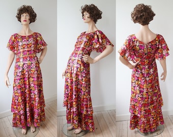 Vestido largo vintage de los años 70, color negro, con estampado floral de colores brillantes y líneas doradas // Talla S