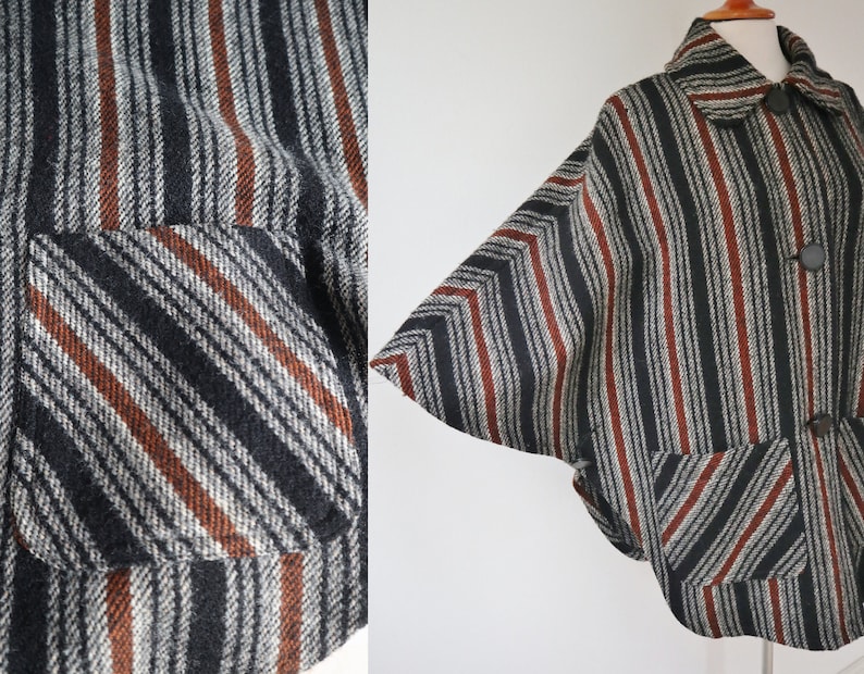 May include: A vintage cape-style jacket with a striped pattern in black, gray, and rust-colored stripes. The jacket features a collar, large buttons, and two front pockets. The fabric has a textured appearance.