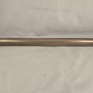 Puede incluir: Una barra de metal larga, delgada y de color plateado con extremos redondeados.