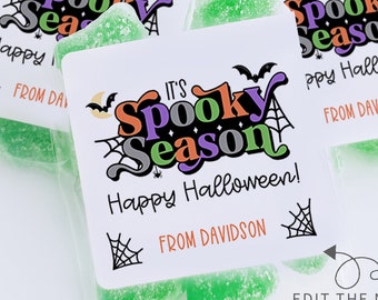 May include: Several clear cellophane bags filled with green candies. Each bag has a white label with the text "IT'S Spooky Season Happy Halloween!" and "FROM DAVIDSON" in a Halloween-themed design with bats and spiderwebs.