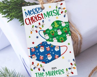 May include: A white gift tag with the words "MERRY CHRISTMASK" in blue and red. The tag features illustrations of Christmas-themed face masks, including snowmen and Santa Claus. The tag is tied with twine.