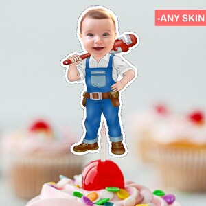 May include: A cartoon illustration of a baby wearing blue overalls and a tool belt, holding a wrench over their shoulder. The image is a printable cake topper.