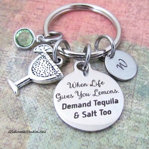 May include: Silver keychain with a margarita glass charm, a green crystal charm, and a round tag that says "When life gives you lemons, demand tequila & salt too".