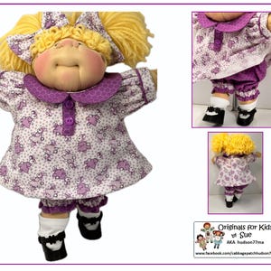Può includere: Una bambola Cabbage Patch Kid che indossa un vestito viola e bianco con un motivo floreale e scarpe nere. La bambola ha i capelli biondi e un colletto viola. La bambola è in piedi su uno sfondo bianco.  Originals for Kids by Sue AKA hudson77ma www.facebook.com/cabbagepatchhudson77ma