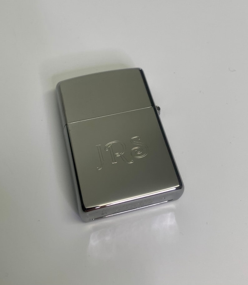 May include: A silver lighter with the initials "J.R.S." engraved on the front.