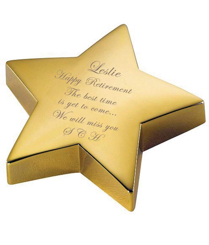May include: A gold star-shaped paperweight with an engraved message that reads "Leslie Happy Retirement The best time is yet to come... We will miss you SCH".