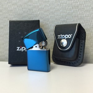 Op maat gemaakte zippo-aansteker met saffier en leren riemzakje, gratis gegraveerd. Op maat gemaakte zippo-aansteker en leren zippo-etui, gratis gegraveerd.