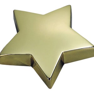 May include: A gold-colored, five-pointed star-shaped paperweight.