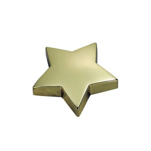May include: A gold-colored star-shaped ornament. The star is made of metal and has a smooth, shiny surface.