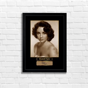 Peut inclure: Photographie en noir et blanc d'Elizabeth Taylor dans un cadre avec une bordure dorée. L'impression comporte une plaque dorée avec son nom et sa signature.