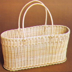 May include: A white wicker basket with two handles. The basket is oval shaped and has a woven design.