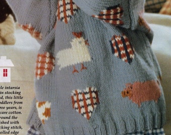 Op de afbeelding: Een blauwe gebreide trui met een kleurrijk intarsia-ontwerp met kippen, harten en een varken. De trui heeft een gerolde zoom en is gebreid met een ribbelsteek.