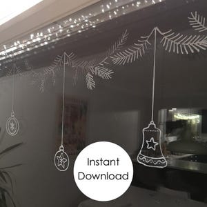 May include: White outline drawing of a Christmas garland with ornaments and a bell hanging from it. The garland is drawn on a dark surface. The text "Instant Download" is in a white circle on the image.