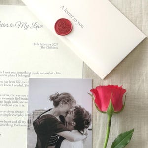 May include: A romantic composition with a red rose, a black and white photograph of a couple kissing, and two letters. One letter is sealed with a red heart-shaped wax seal and reads "A letter to you". The other letter reads "Letter to My Love".