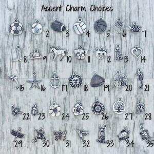 K&ouml;nnte beinhalten: Eine Sammlung von 35 silbernen Charms f&uuml;r die Schmuckherstellung. Die Charms umfassen Sportb&auml;lle, Tiere, von der Natur inspirierte Designs und mehr.