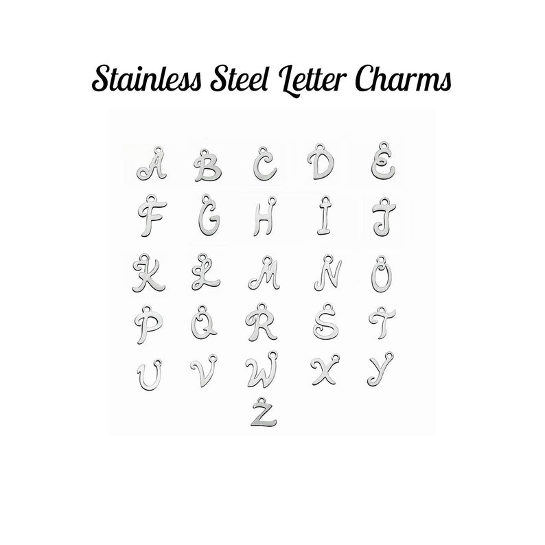 May include: Stainless steel letter charms in a cursive font. The letters A through Z are displayed in alphabetical order.
