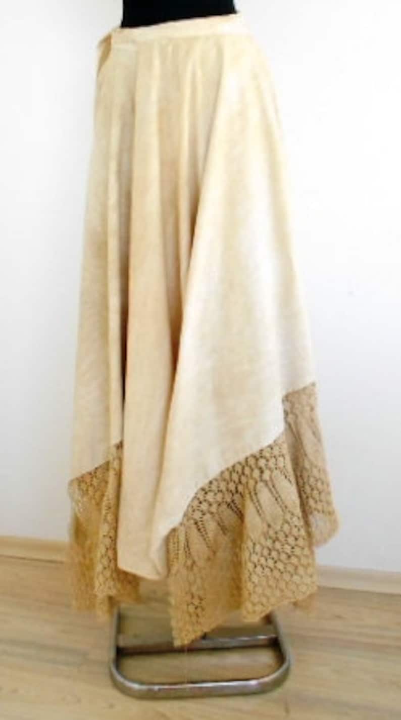 May include: A long, white, flowing skirt with a lace trim. The skirt is made of a lightweight fabric and has a simple, elegant design.
